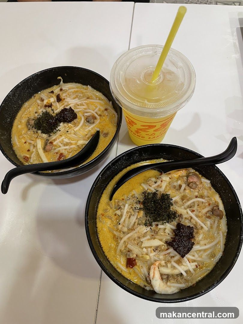 Two bowls of Laksa with a drink