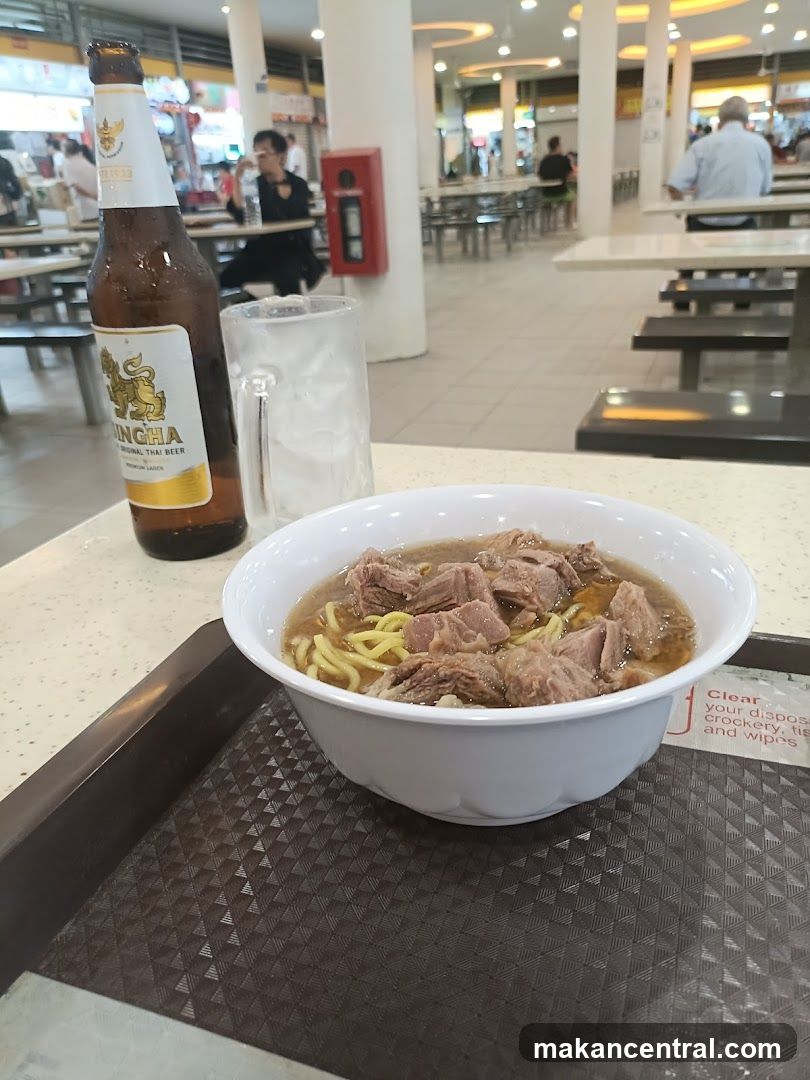 Bowl of noodles with beef and a bottle of Singha beer