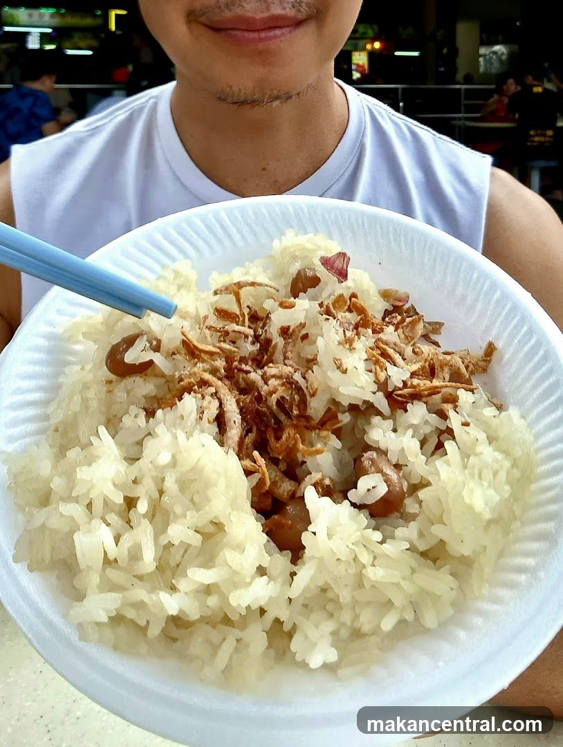 Person holding a bowl of sticky rice with toppings