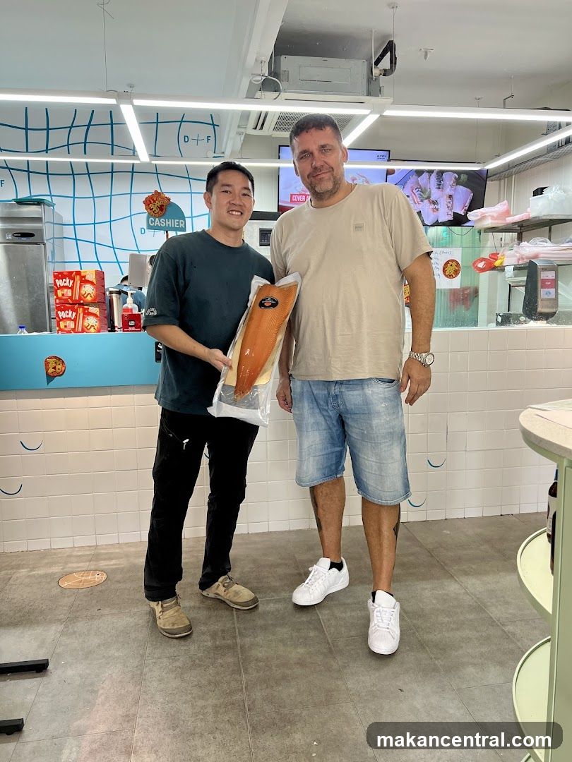 Two men holding a package of salmon