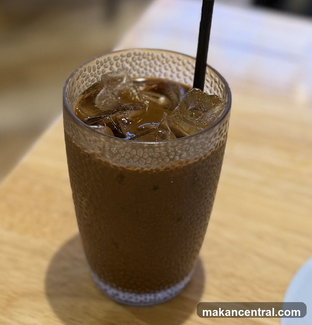 Iced beverage in textured glass with black straw