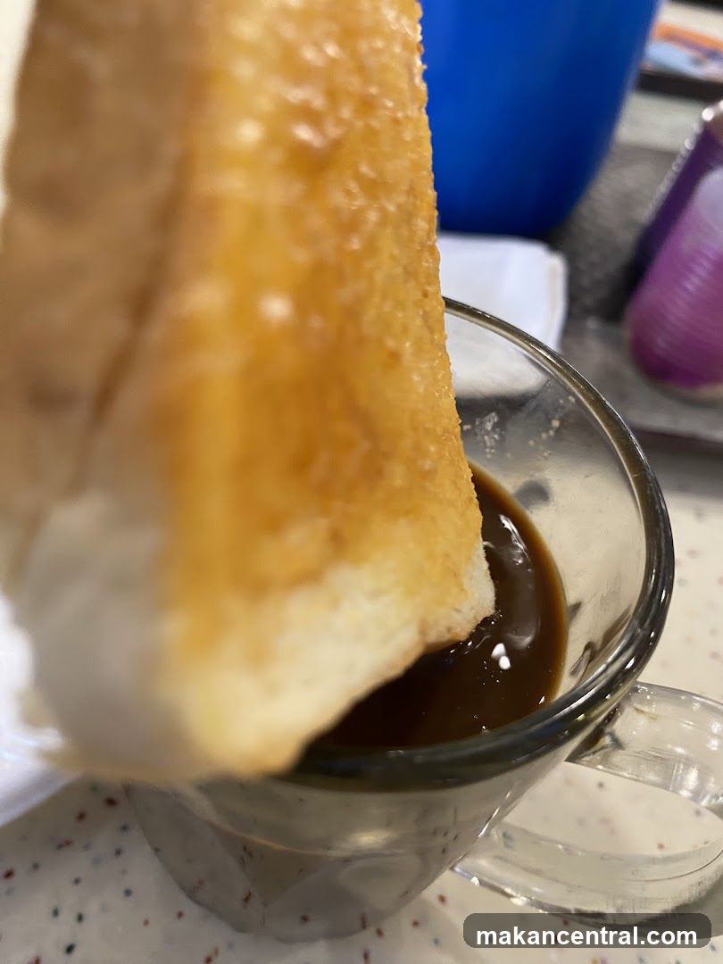 Close-up of toast dipping into coffee