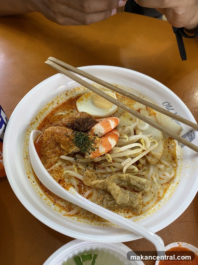 Laksa bowl with chopsticks and spoon