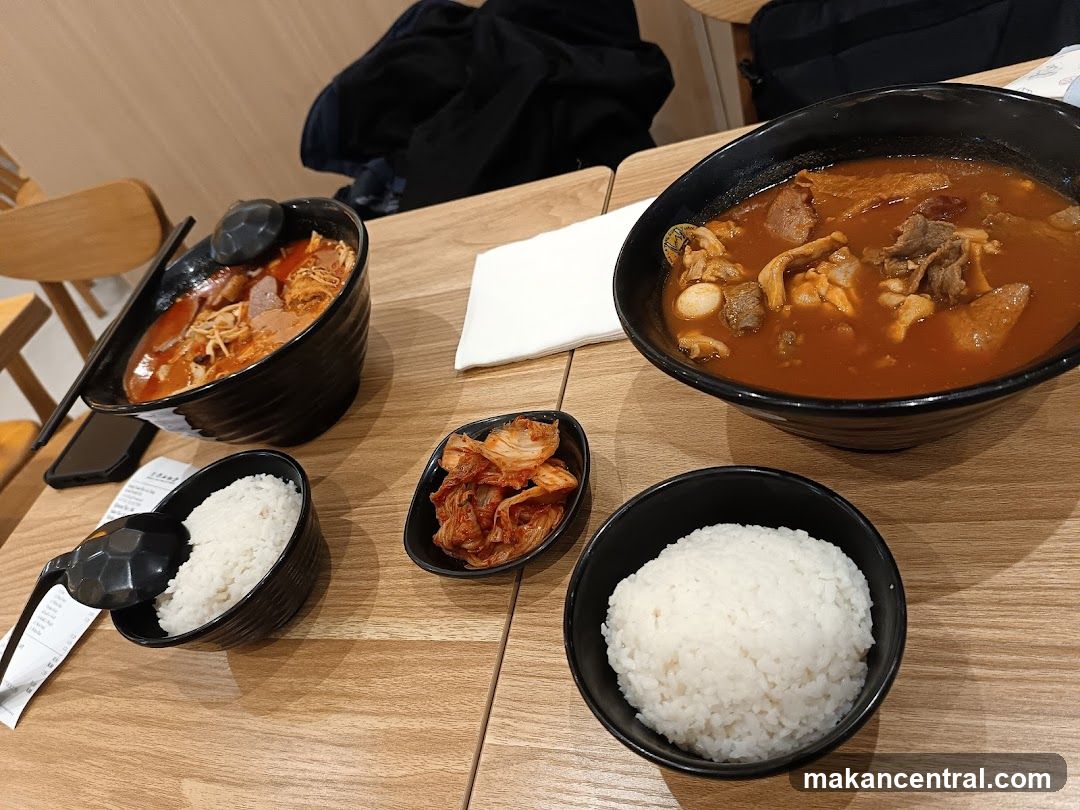 Two bowls of soup with rice and kimchi