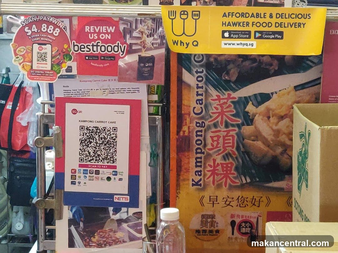 Promotional signage and payment QR codes at a food stall
