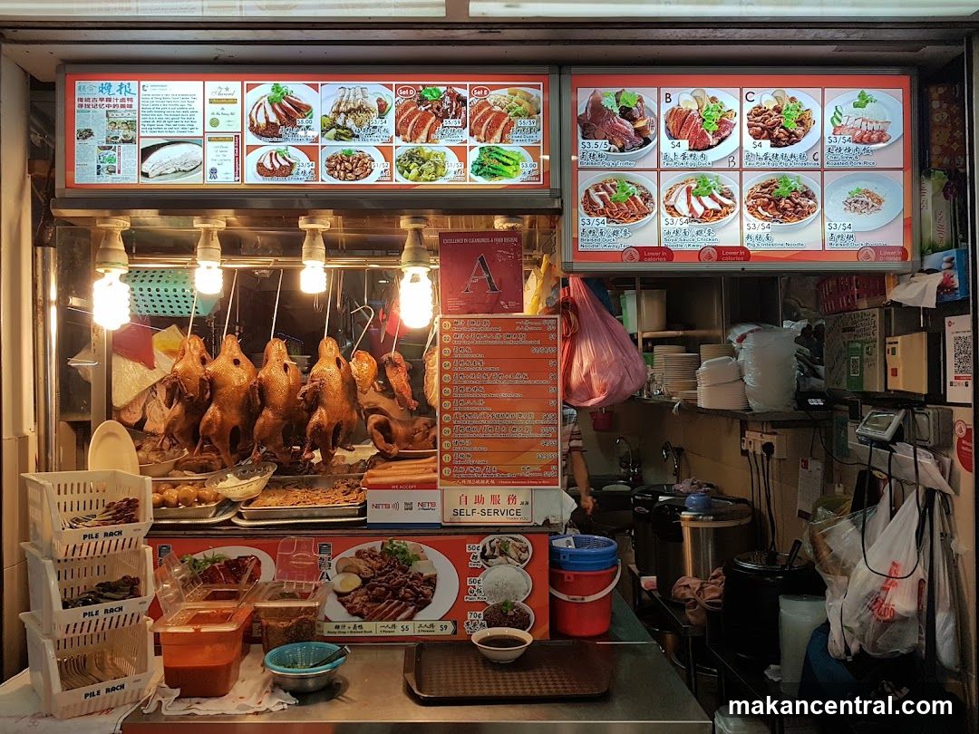 Food stall interior with roasted ducks and menus