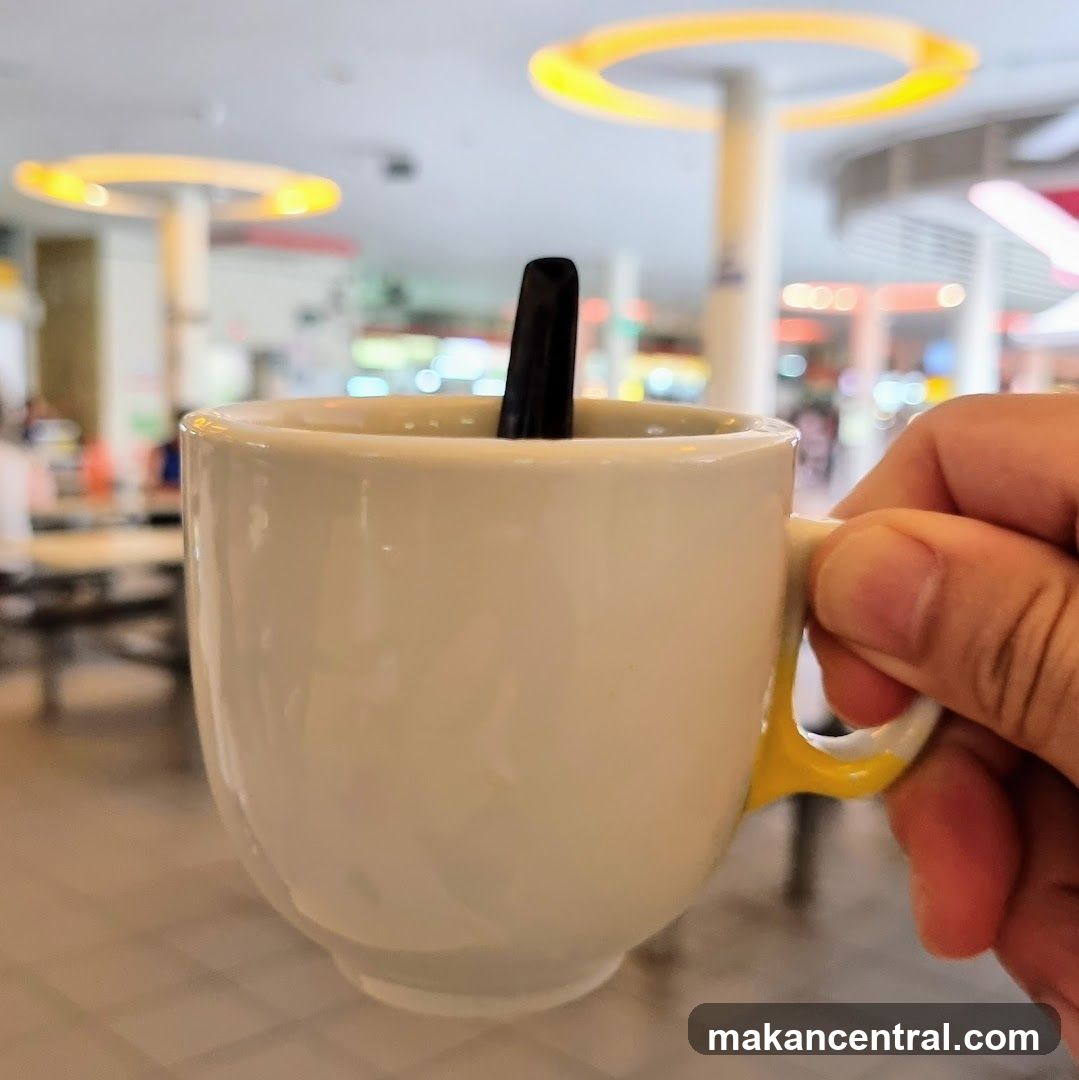 Hand holding a cup in a food court
