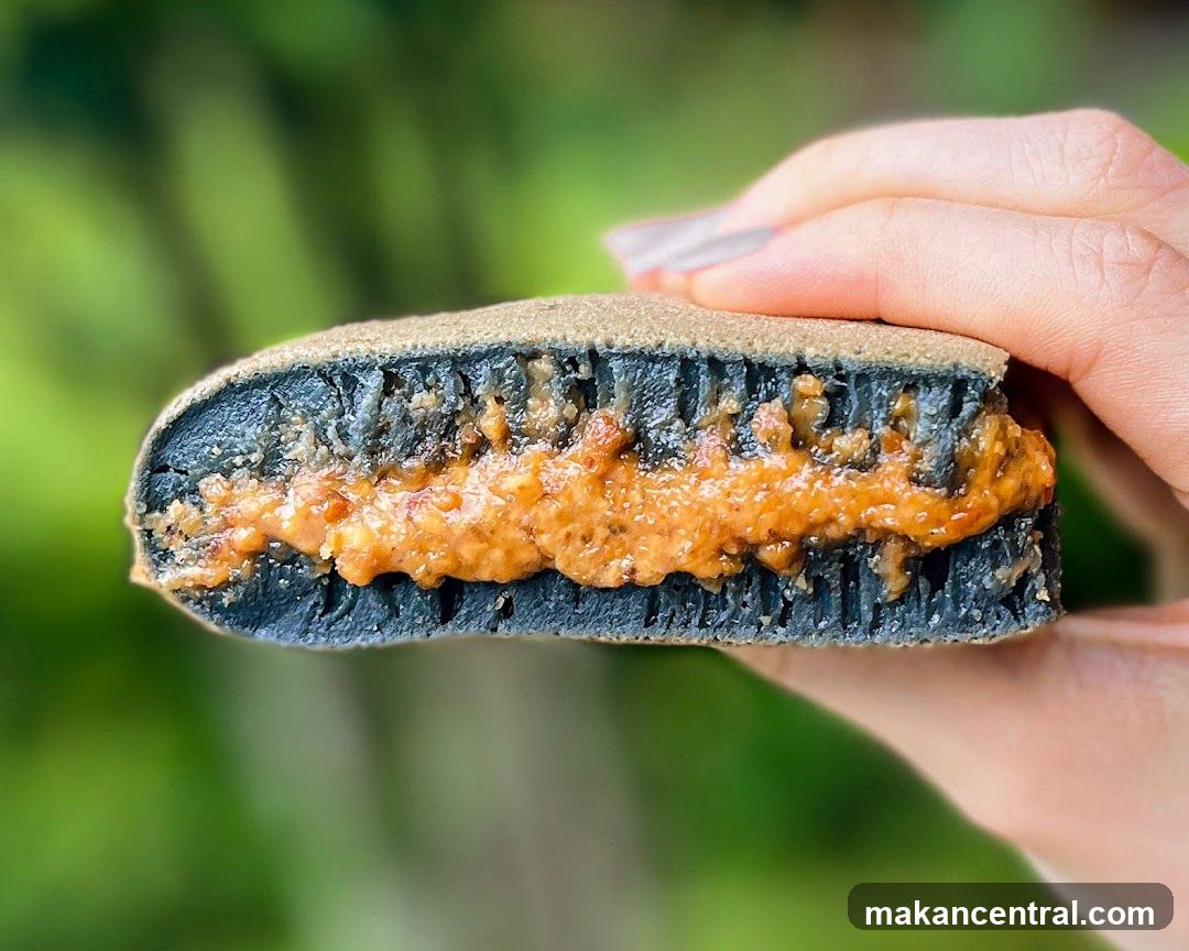 Close-up of a charcoal-colored pancake filled with peanut butter