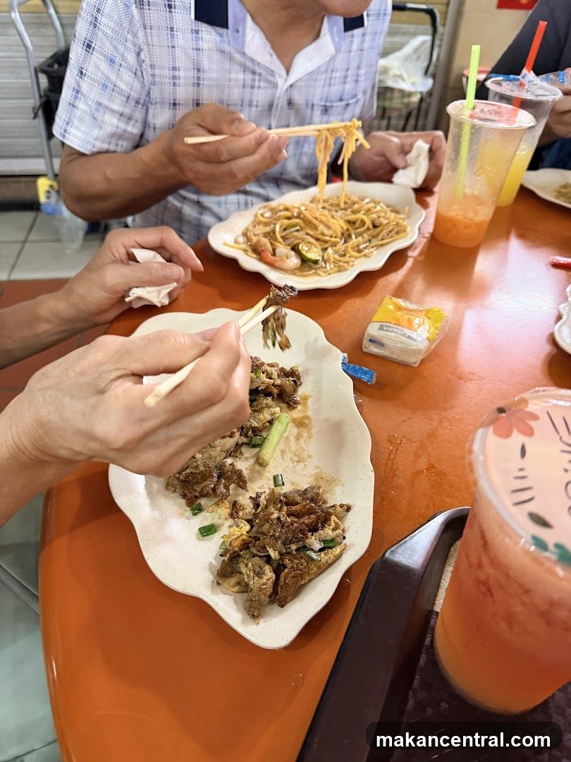 People eating noodles and other dishes at a table
