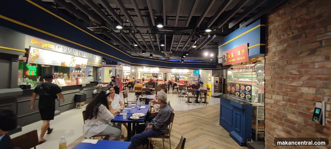 Food court with various stalls and seating areas