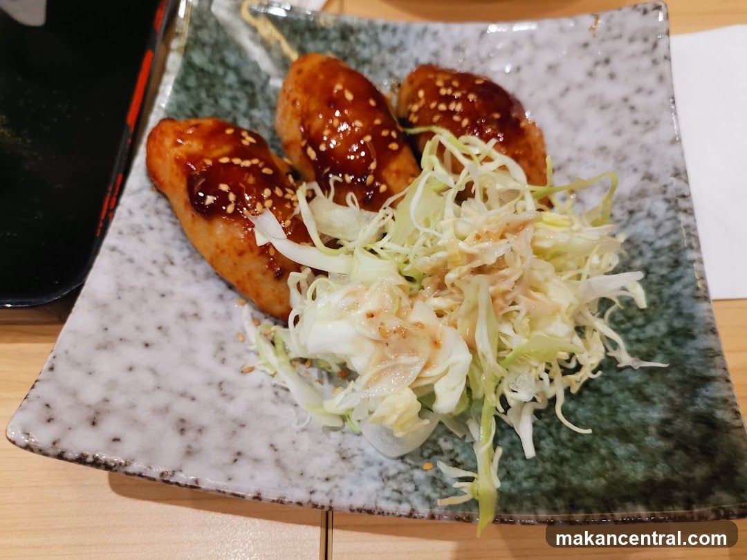 Three glazed chicken pieces with shredded cabbage salad