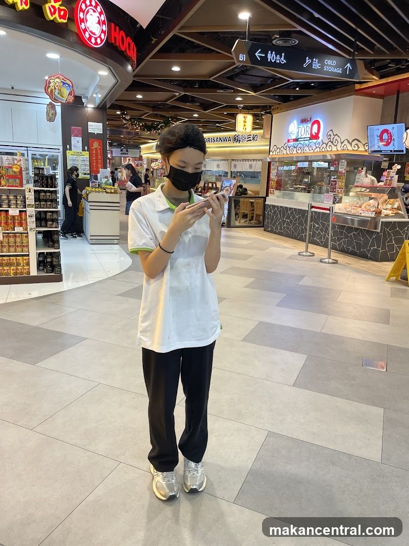 Food court scene with a person looking at their phone