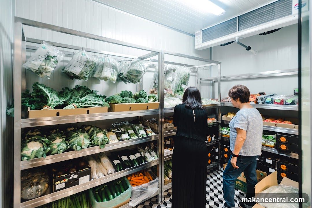 Two women browsing produce in a refrigerated section