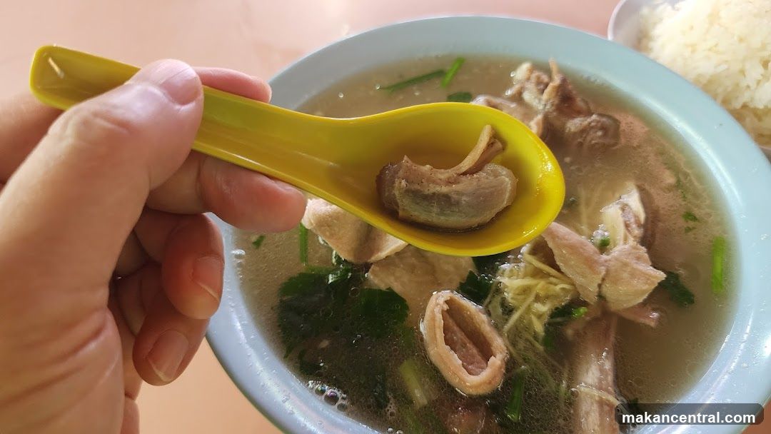 Close-up of a bowl of soup with meat and a spoon