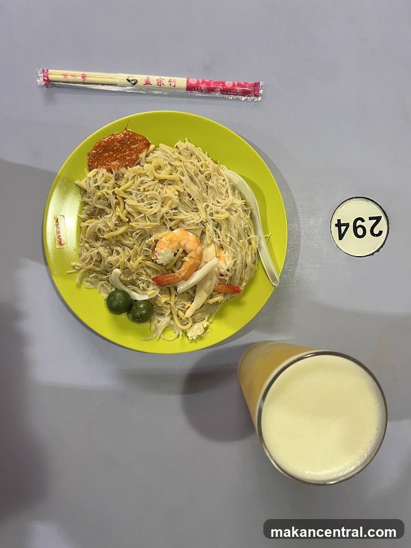 Plate of noodles with shrimp and a drink