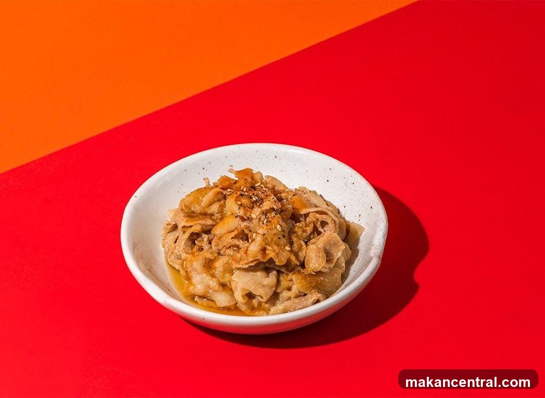 Bowl of thinly sliced meat with sesame seeds