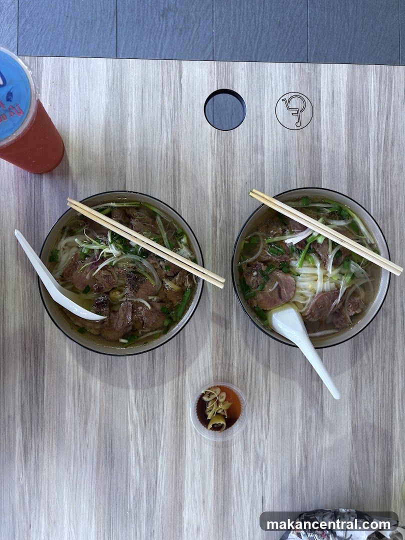 Two bowls of pho and a drink