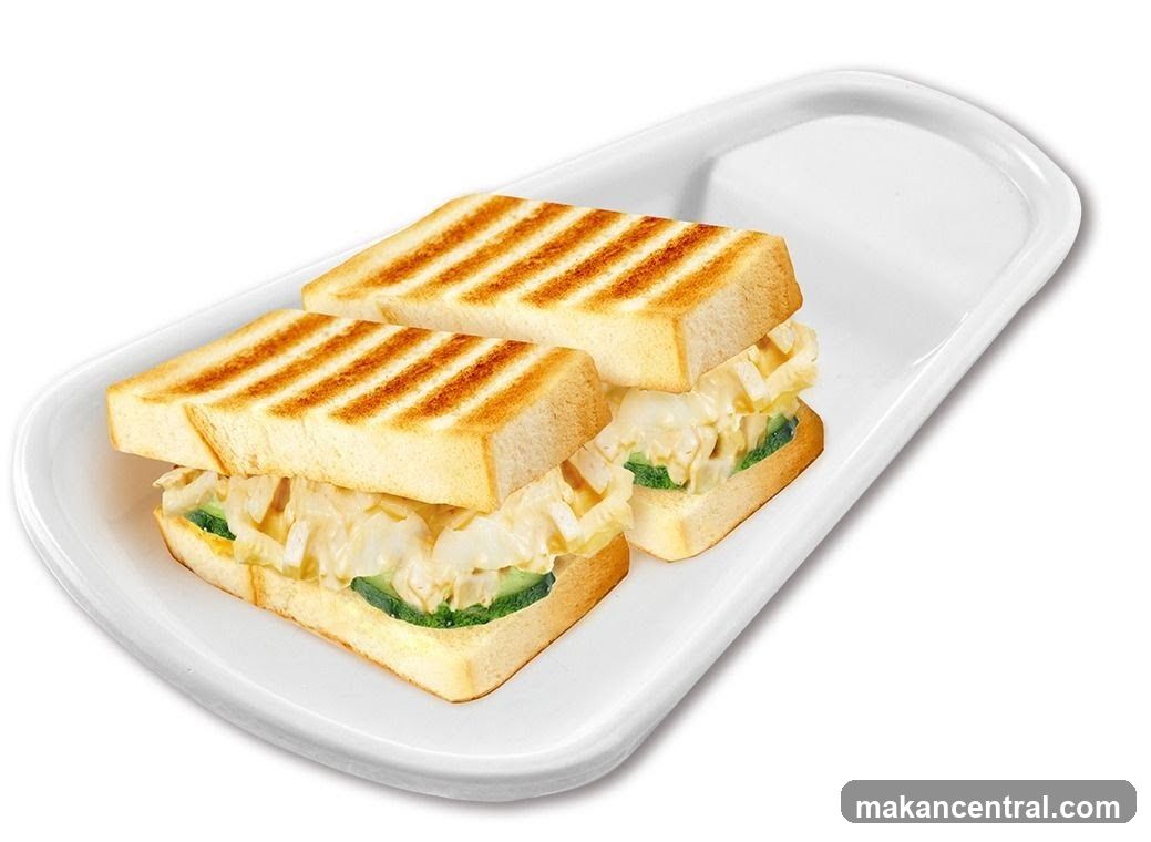 Two grilled sandwiches on a white plate