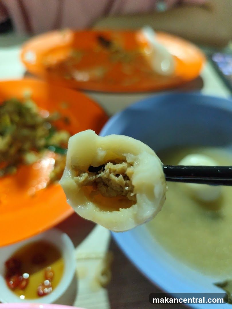 Close-up of a dumpling being held by chopsticks