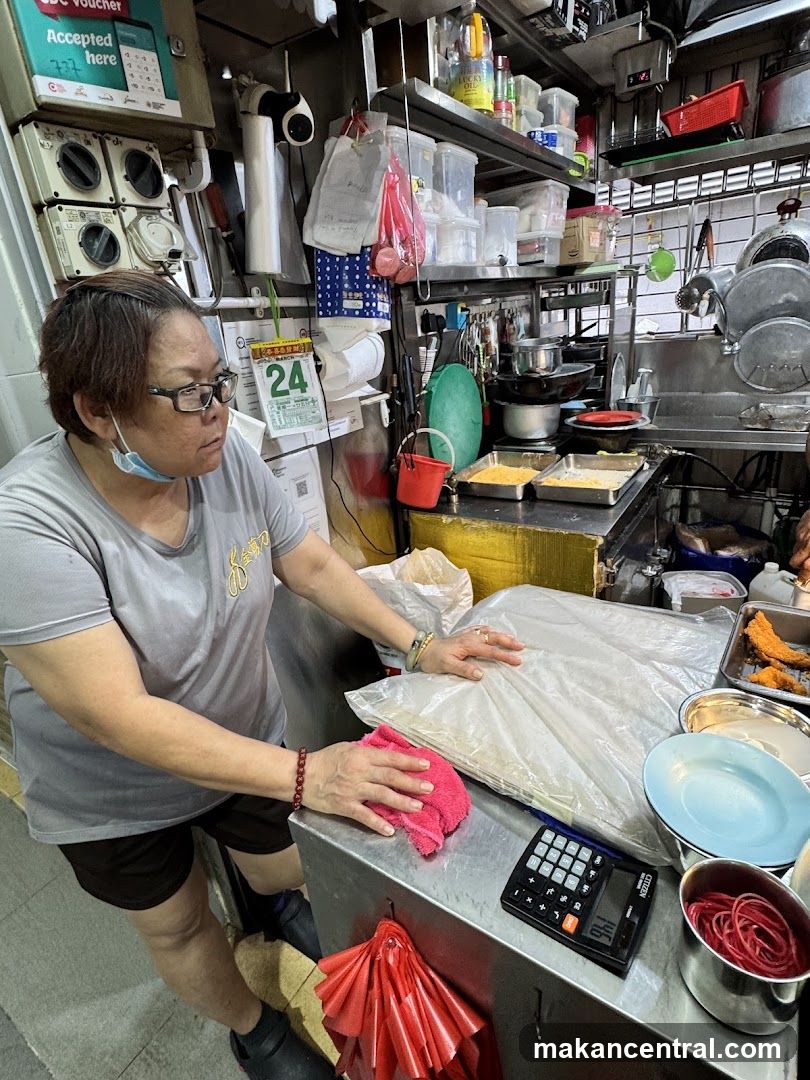 Food stall worker cleaning counter