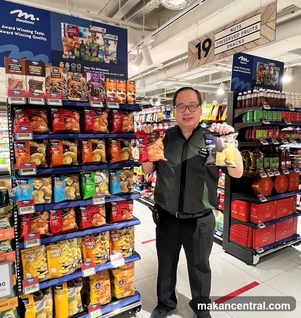Man holding snacks in a supermarket aisle
