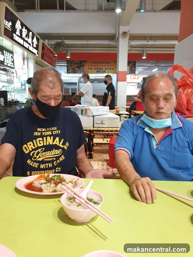 Two Men Eating at a Food Stall