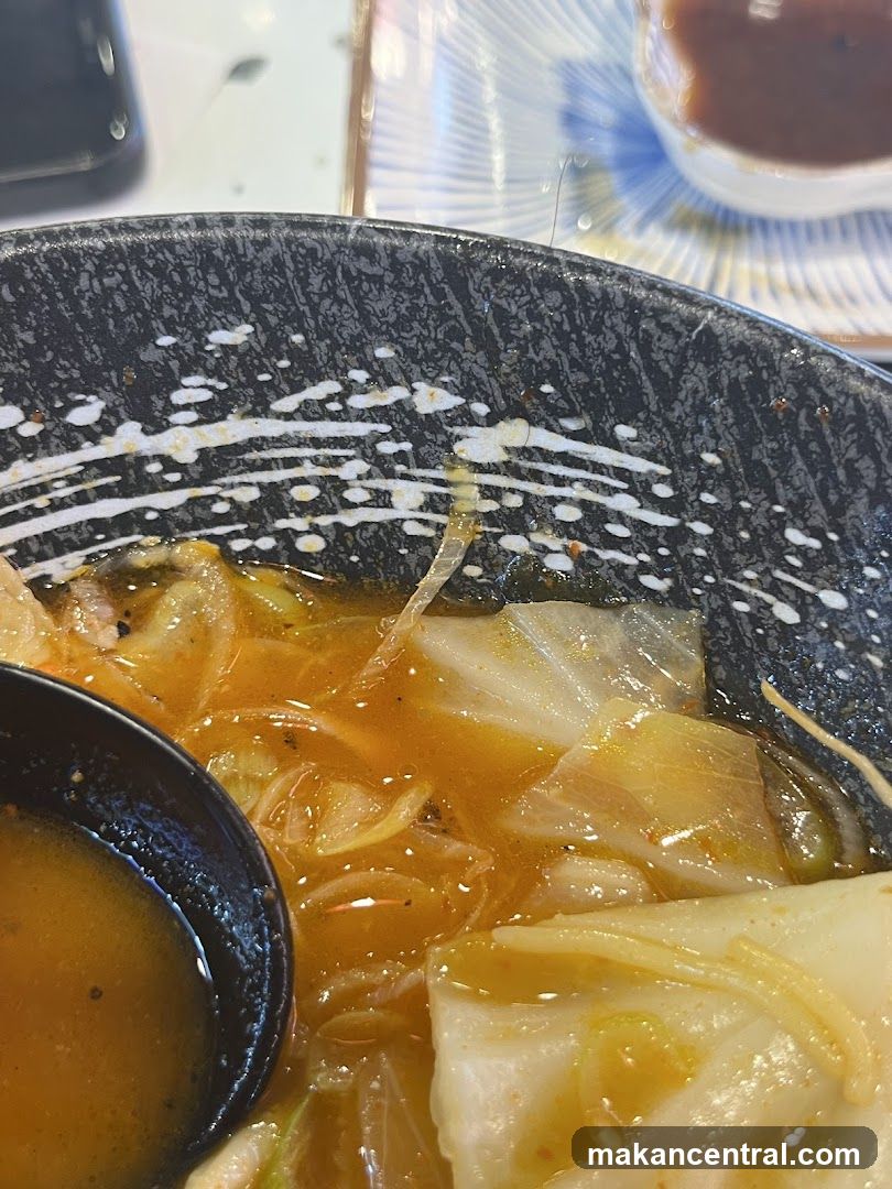 Bowl of noodles with cabbage and a spoon