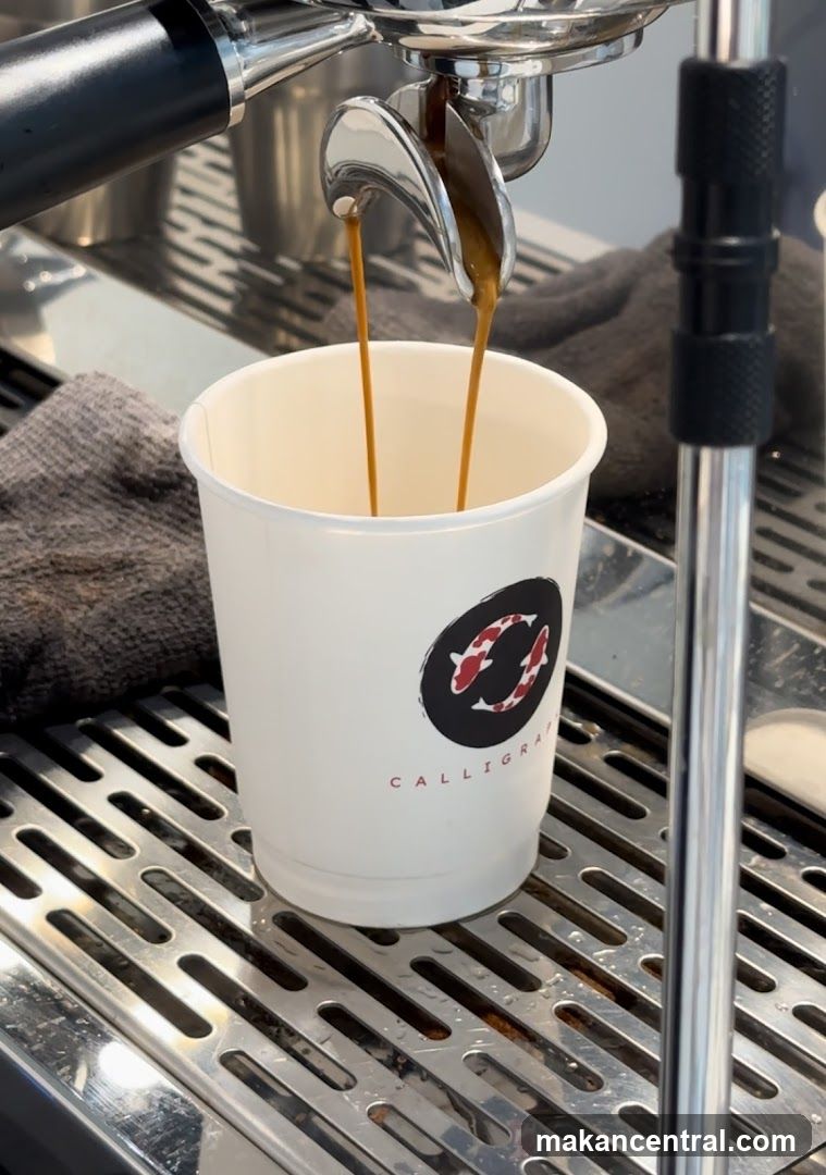 Espresso Being Poured into a Branded Cup