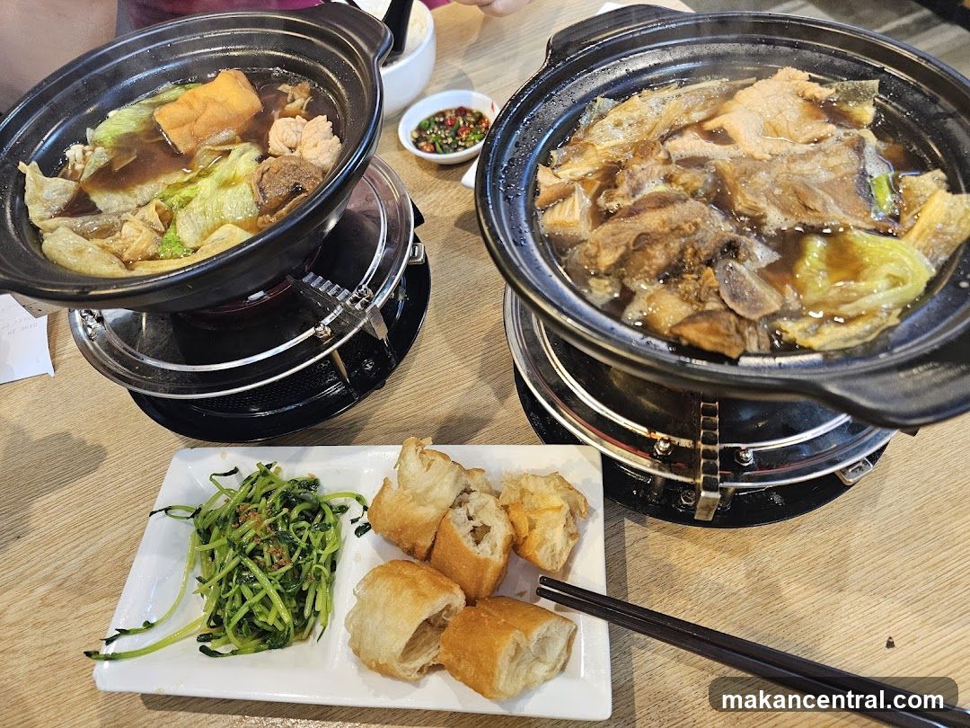 Two bowls of bak kut teh with side dishes