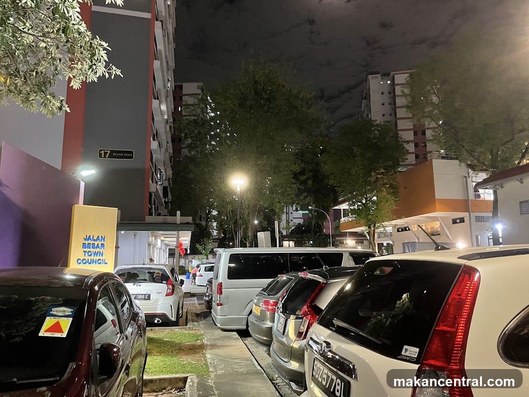 Street scene at night with parked cars and buildings