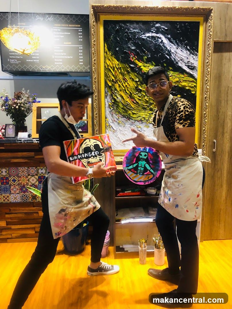 Two people holding paintings in a cafe