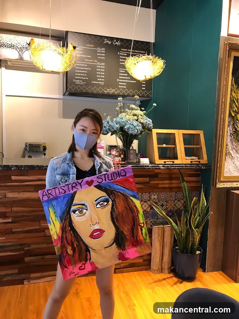 Woman holding a painting in an art studio