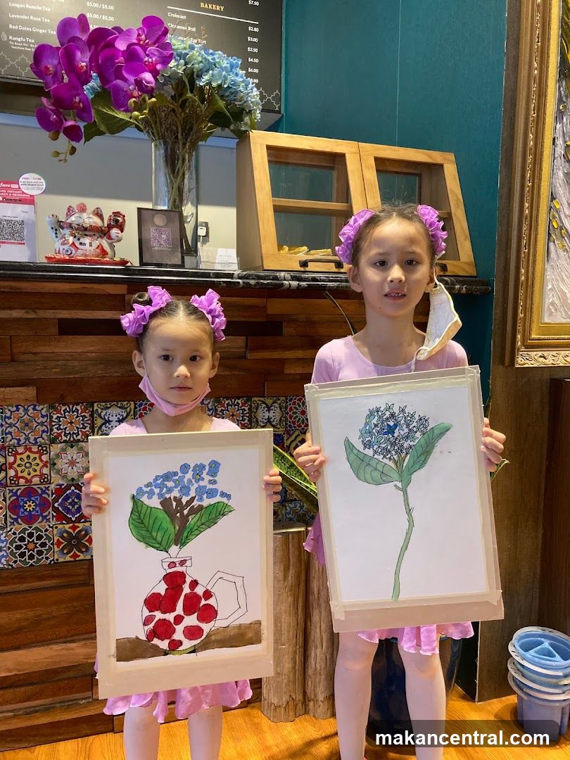 Two girls holding up their artwork