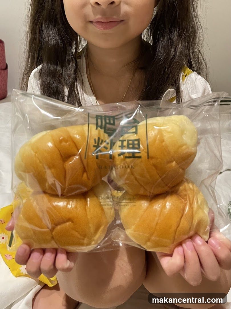 Child holding a bag of bread rolls
