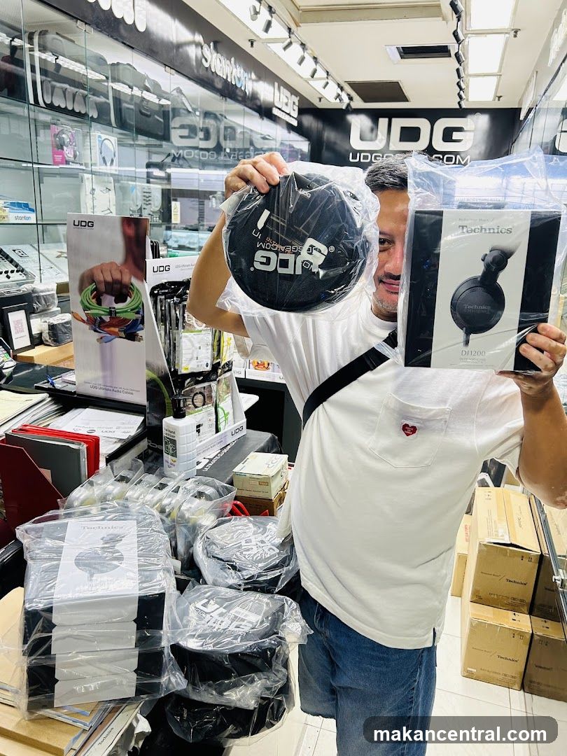 Man holding DJ accessories in a store
