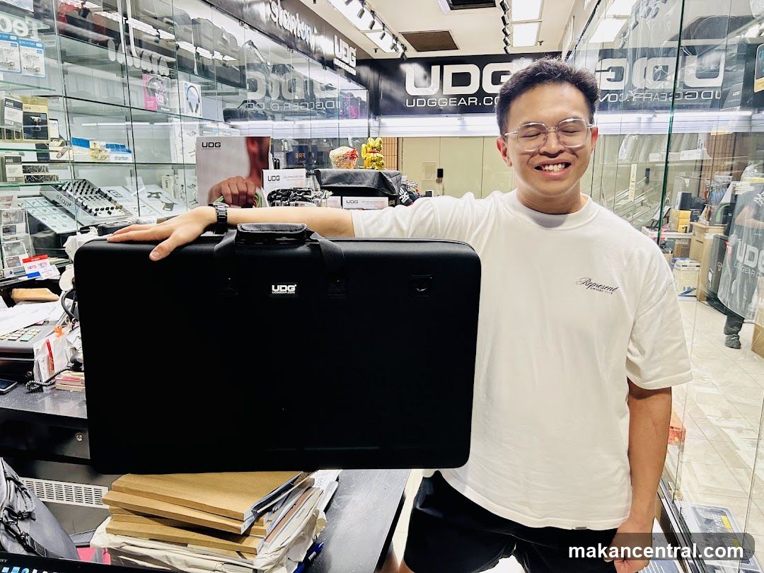 Man holding a black UDG gear bag