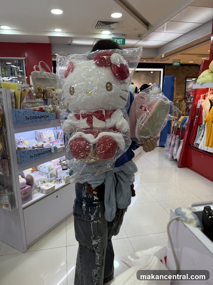 Person holding Hello Kitty plush and slippers