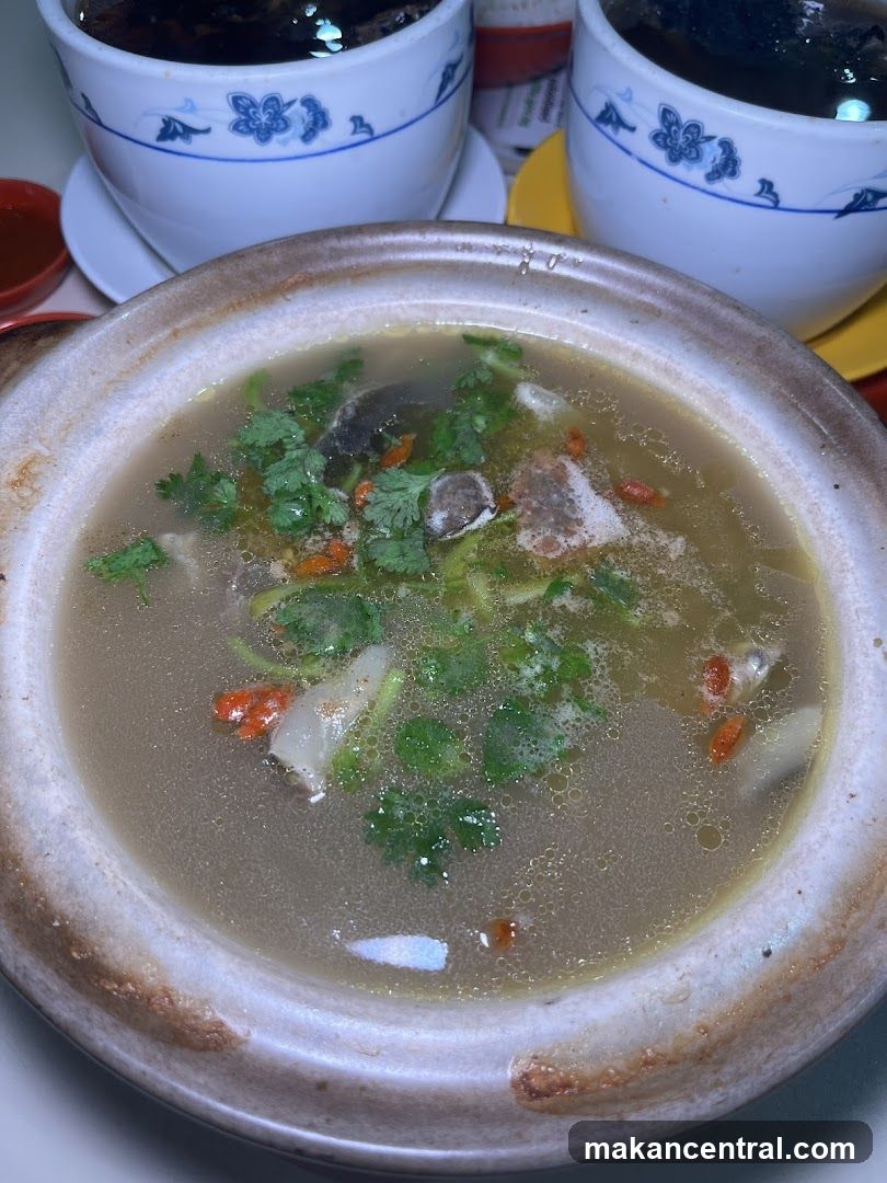 Soup in ceramic bowl with two cups in background