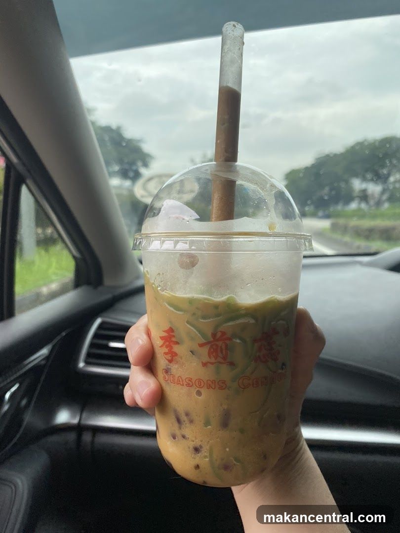 Hand holding iced beverage in car