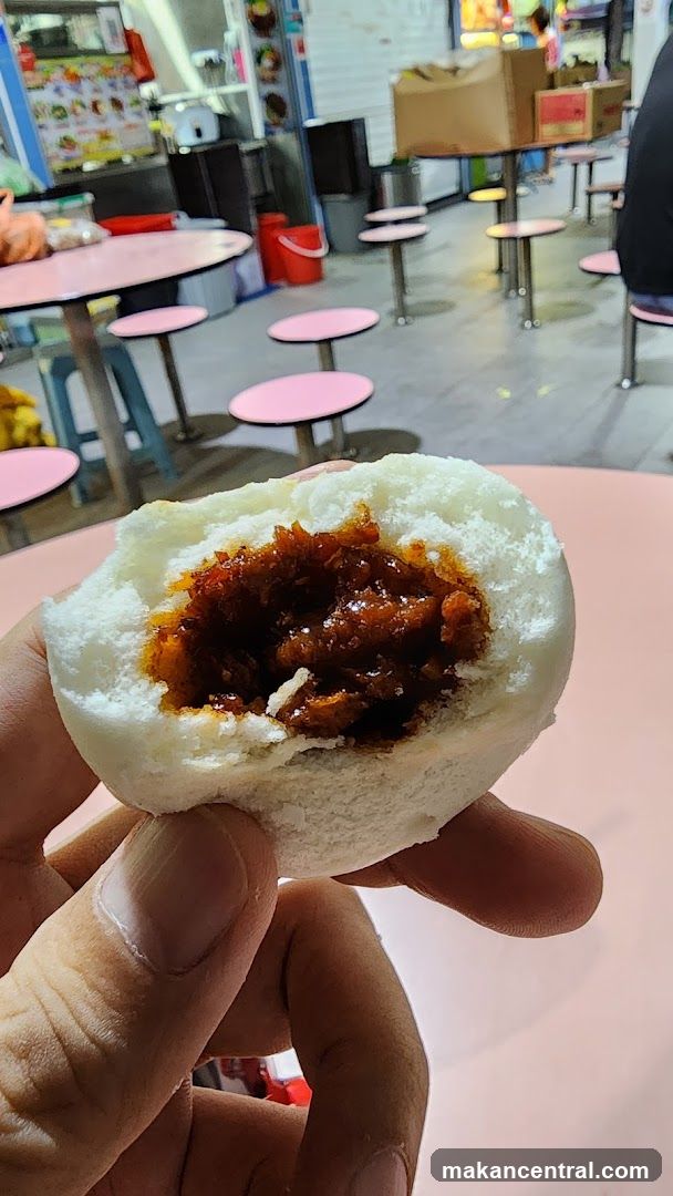 Hand holding a halved bun with filling