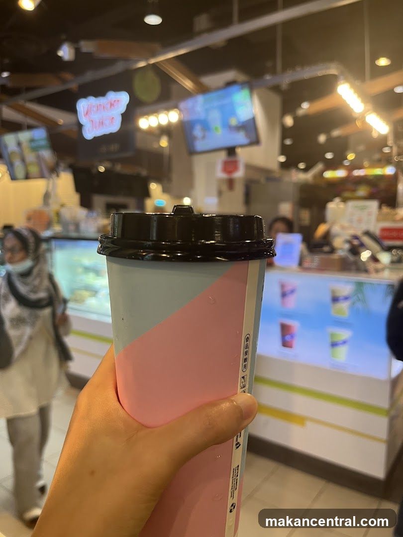 Hand holding drink in food court