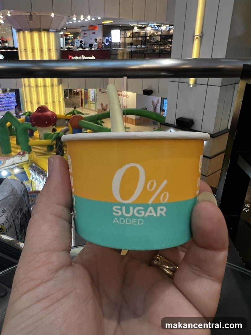 Hand holding a 0% Sugar Added cup