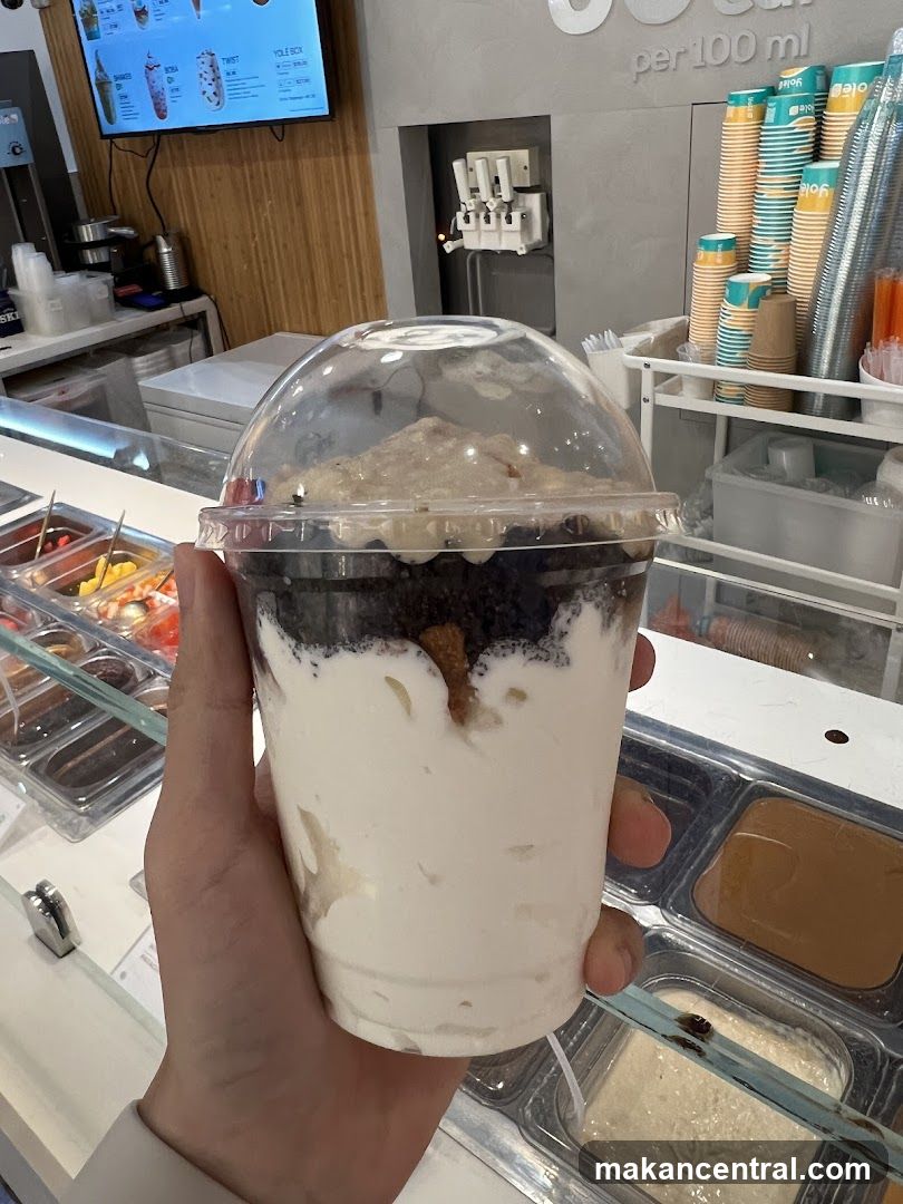 Hand holding dessert cup in ice cream shop