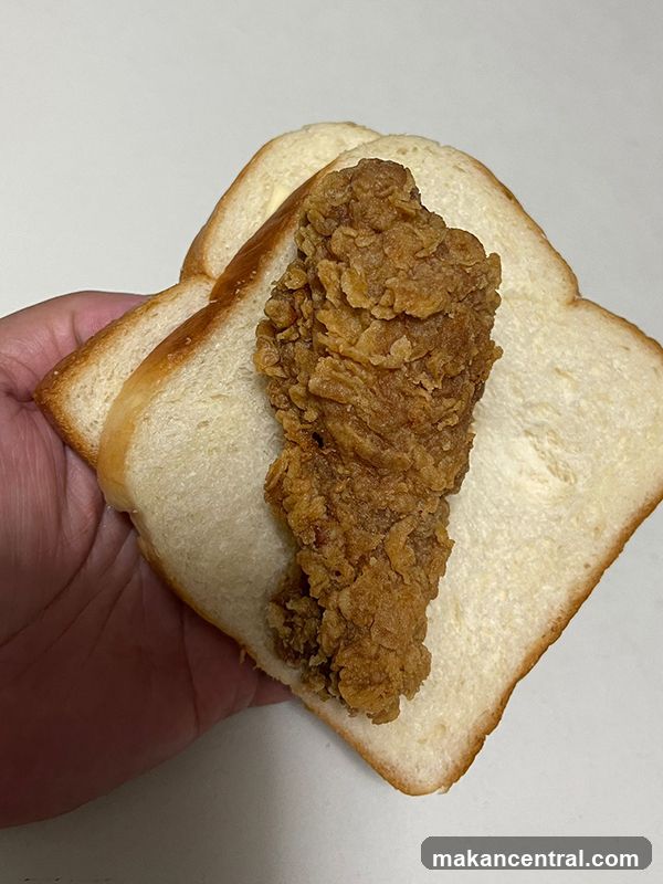 Hand holding fried chicken sandwich