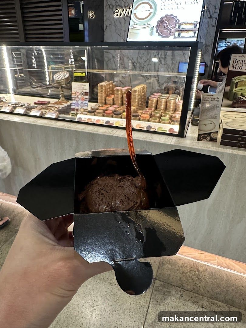 Hand holding chocolate dessert in black box