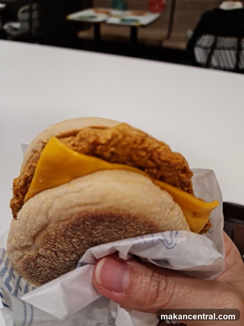 Hand holding breakfast sandwich