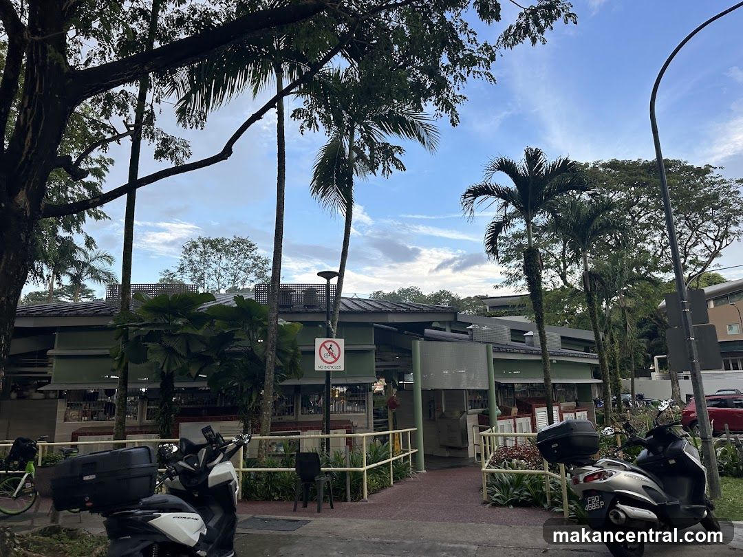 Outdoor view of a building entrance with trees and parked scooters