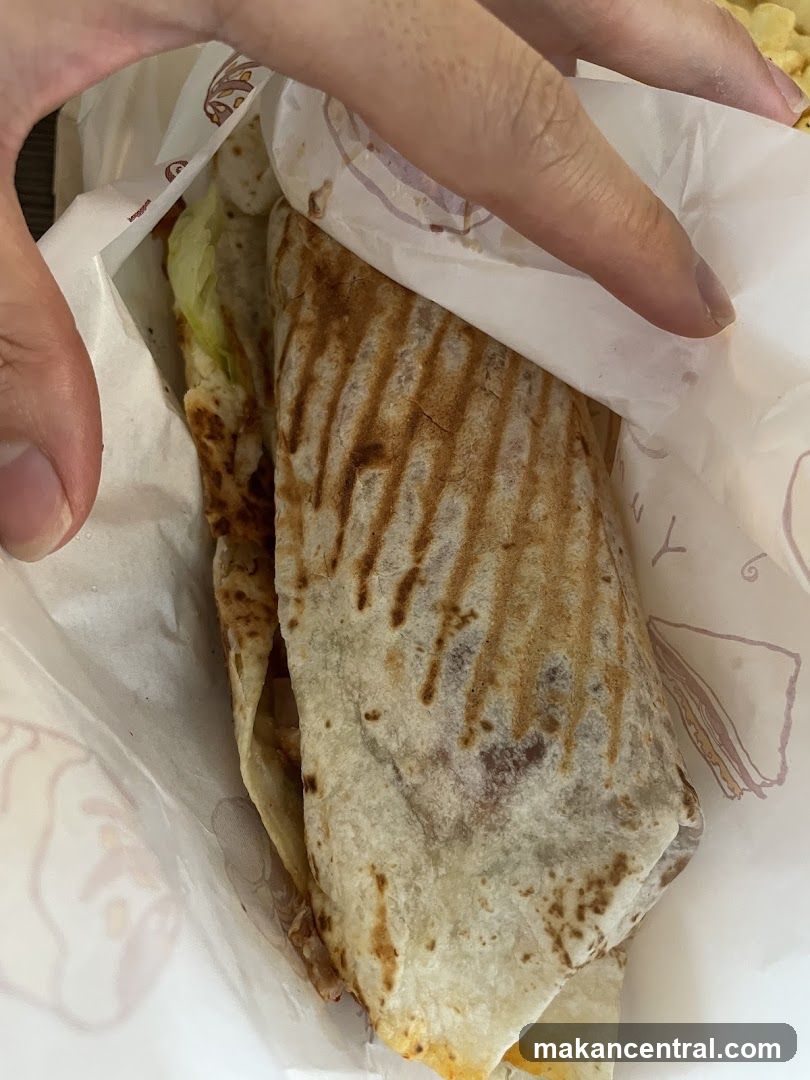 Hand holding wrapped food item