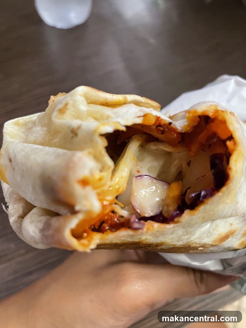 Hand holding a partially eaten wrap