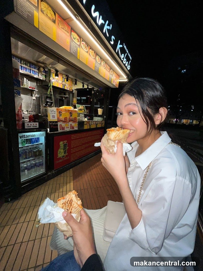 Person eating at night outside a food stall